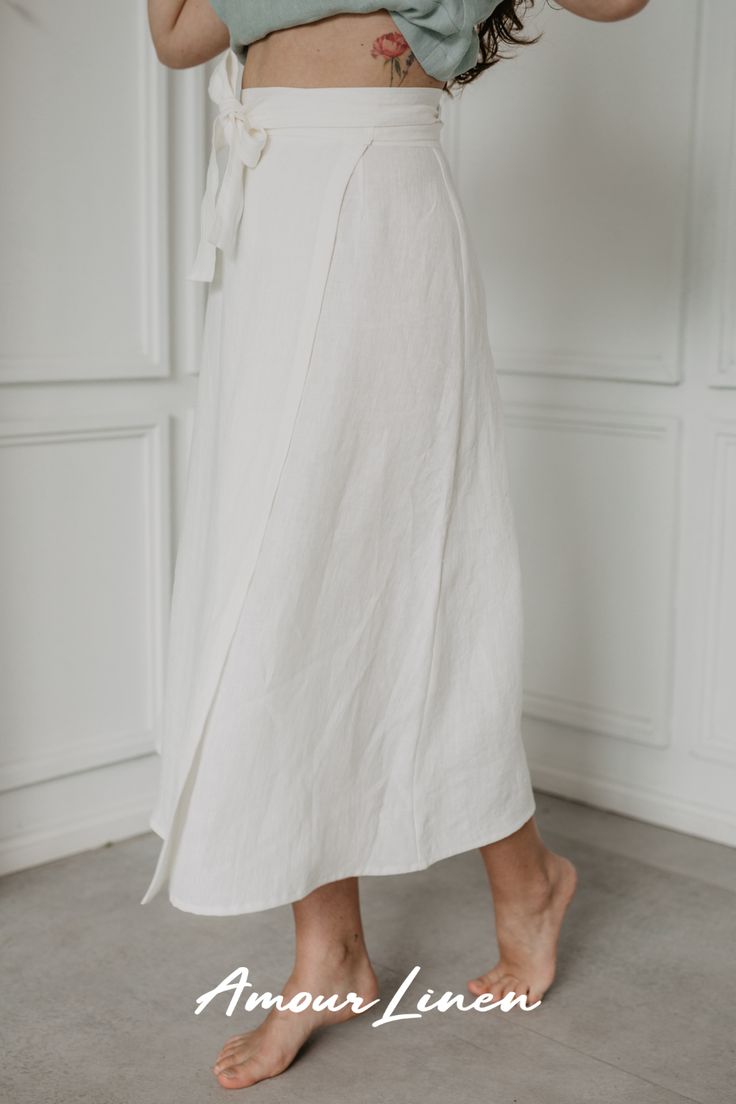 The beautiful midi-length wrap skirt "Iris" by AmourLinen is a versatile addition to any wardrobe. Its wrap style allows for simple outfits with sneakers and a top or a stylish beachy look with a swimsuit. Wear it to work, a picnic, or even a bigger occasion, such as a wedding! Choose from 13 colors and 2 sizes. White Wrap Skirt Outfit, Wrap Skirt Outfit, Outfits With Sneakers, White Wrap Skirt, Linen Wrap Skirt, A Picnic, Linen Skirt, Feminine Look, Modernism