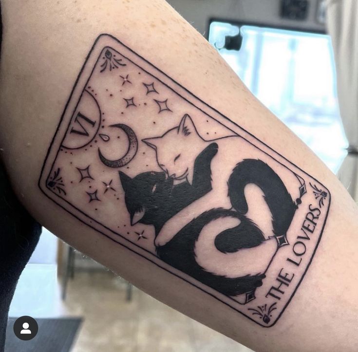 a black and white tattoo on the arm of a person with a cat in it