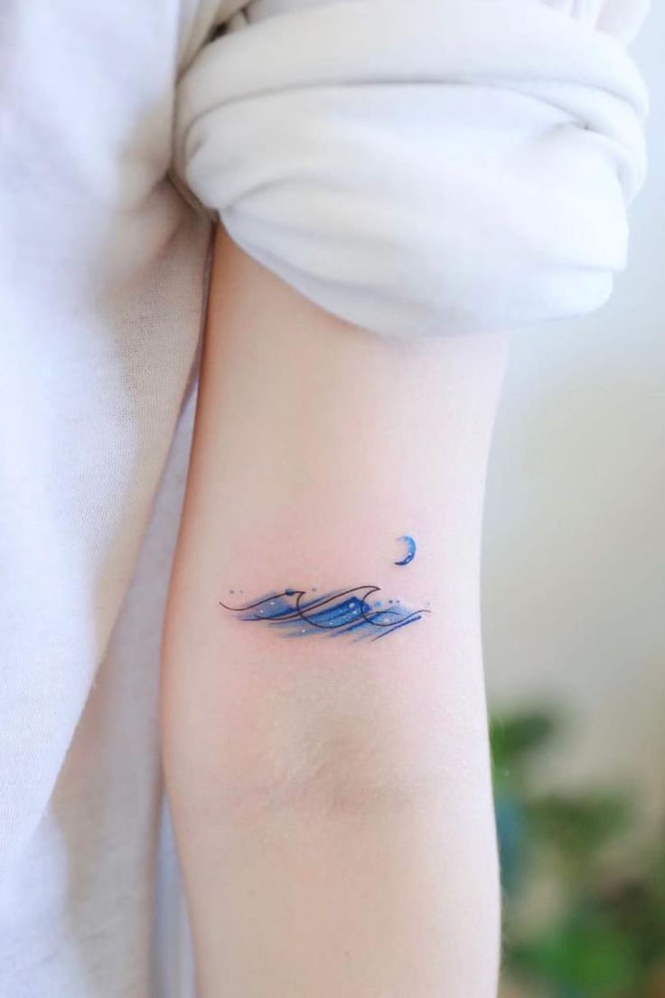 a small wave tattoo on the arm