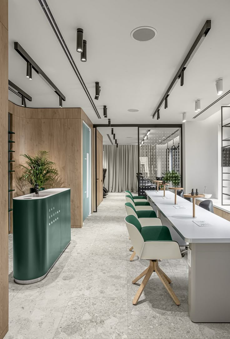 an office with green and white chairs in front of a long table that is next to a plant