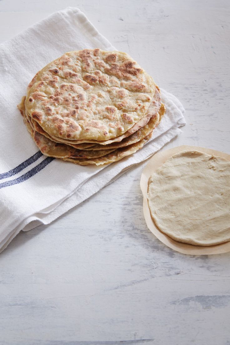 three pita breads sitting on top of a white table next to a napkin