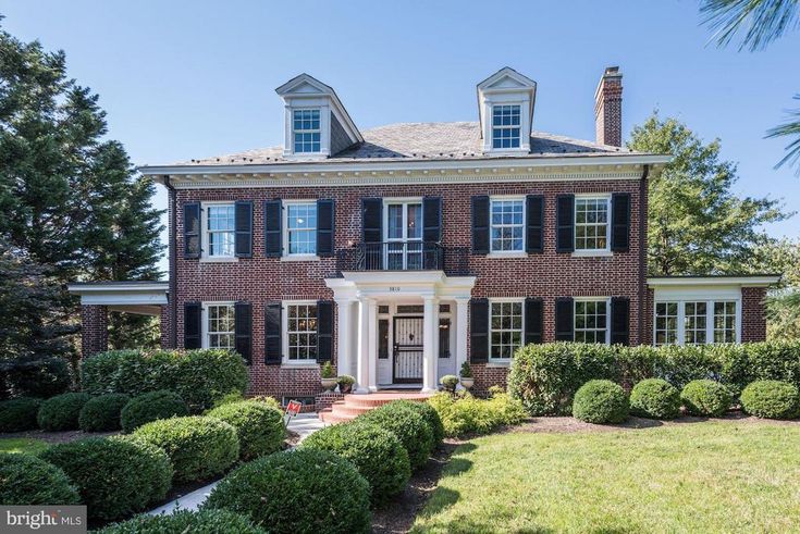 a large brick house with black shutters and white trim