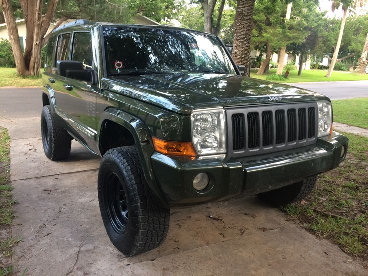 a green jeep parked on the side of a road