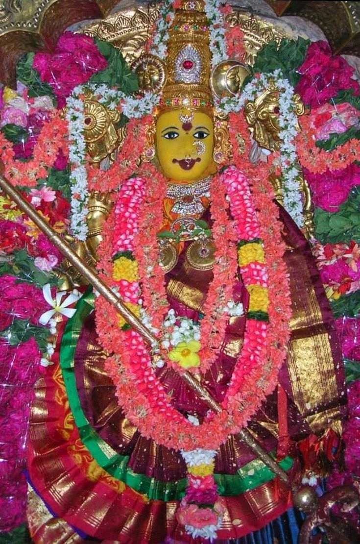 an idol is displayed in the corner of a room with flowers and decorations on it