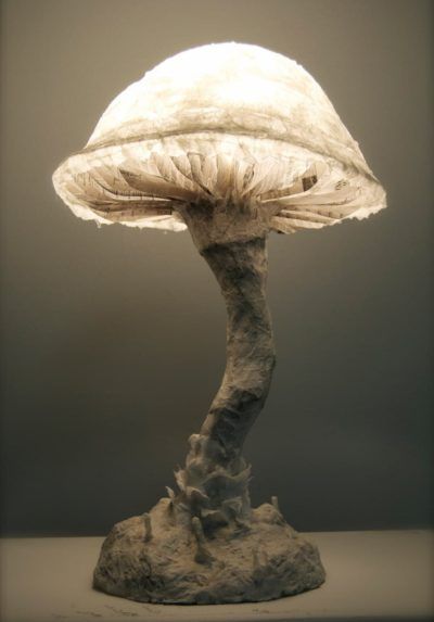 a lamp that is sitting on top of a wooden base with a mushroom like structure