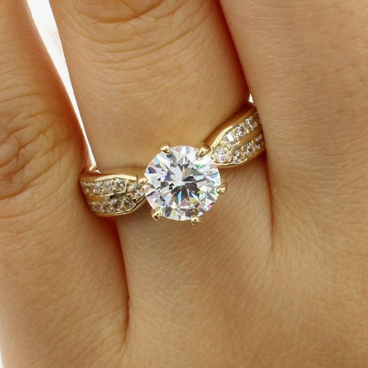 a woman's hand with a diamond ring on top of her finger and an engagement band