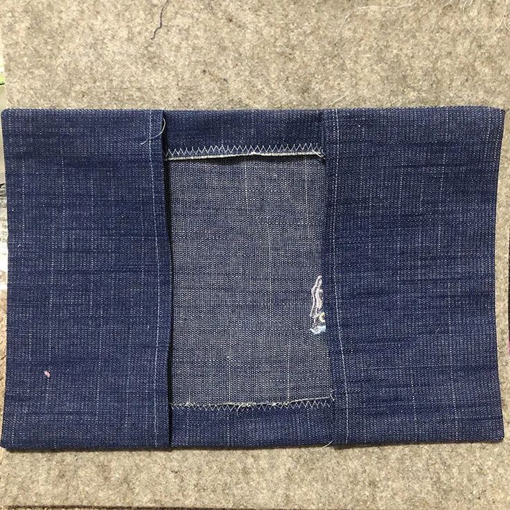 a pair of blue jeans sitting on top of a floor next to a piece of cloth