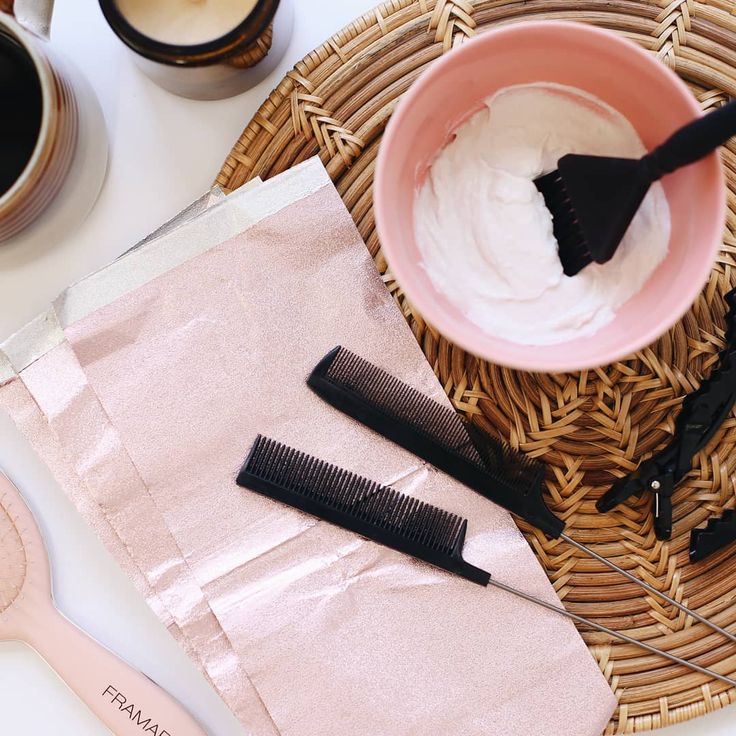 some hair brushes are sitting on a table next to a cup of coffee and a paper towel