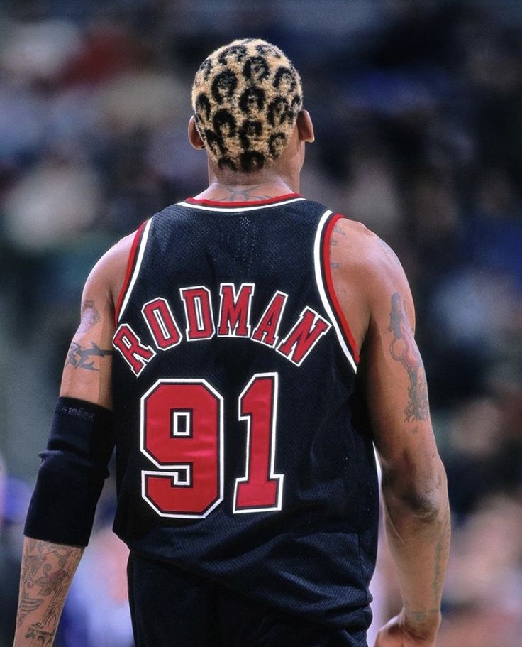 a basketball player with dreadlocks on his head looking down at the court during a game