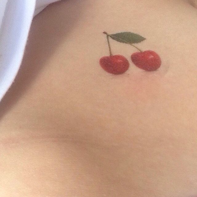 two cherries on the back of a woman's stomach