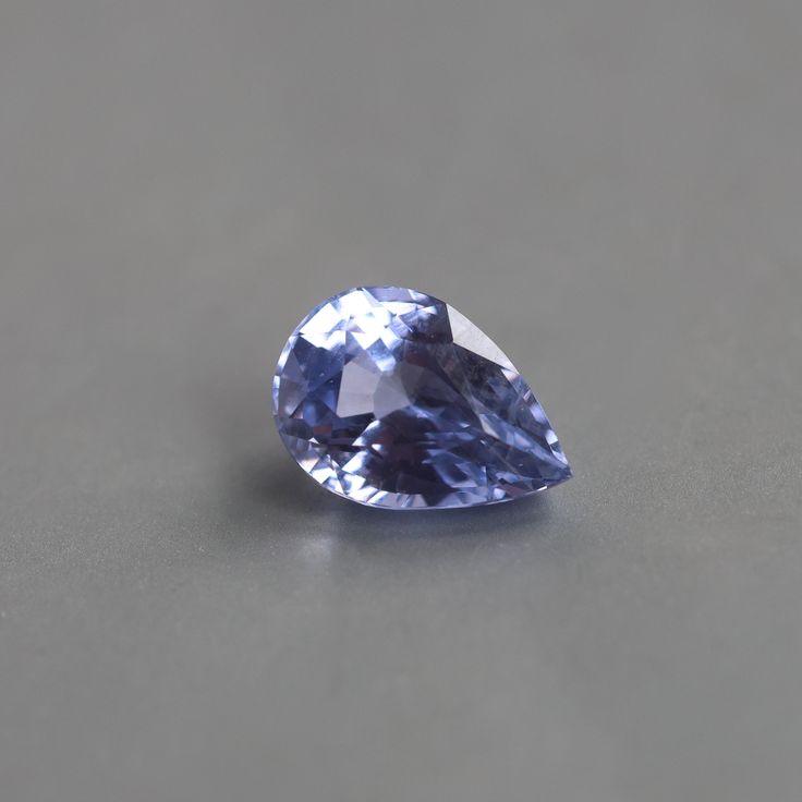 a blue diamond sitting on top of a gray table next to a white wall and floor