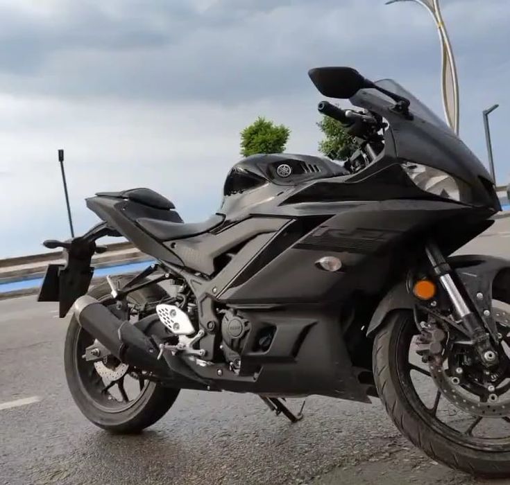 a black motorcycle is parked on the side of the road