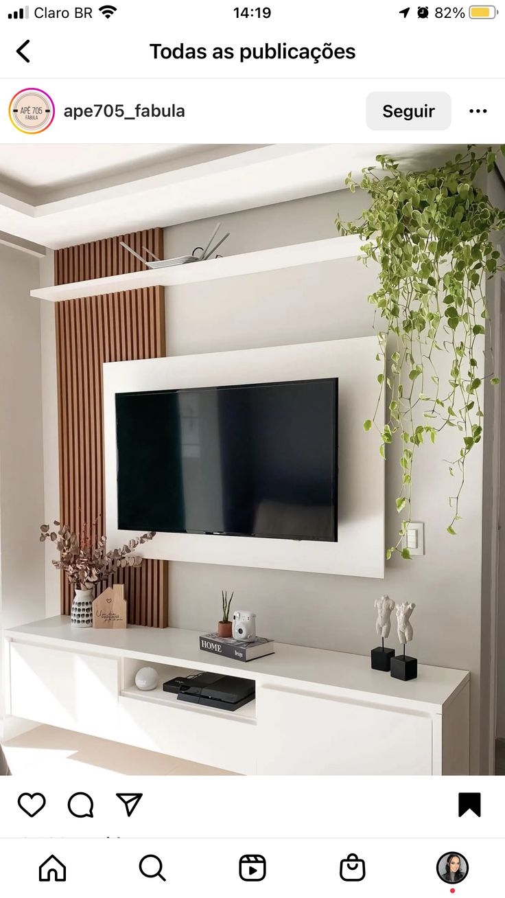 a flat screen tv mounted to the side of a white entertainment center in a living room