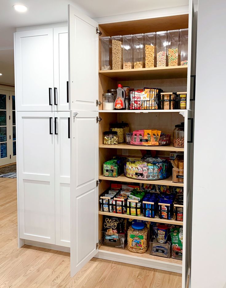 an organized pantry with lots of food in the cupboards and on the floor next to it