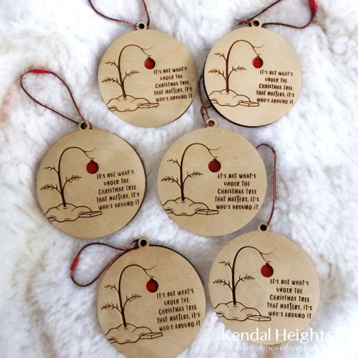 four wooden ornaments with words on them sitting on a white furnishing area next to a red string