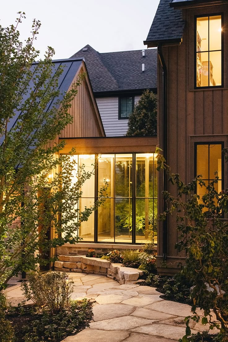 a house that is lit up at night with lights on the windows and steps leading to it