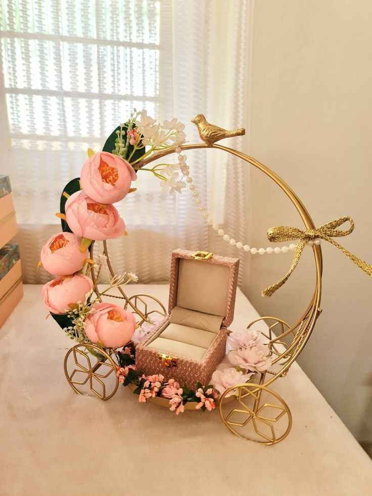 a miniature carriage with flowers and a bird on it