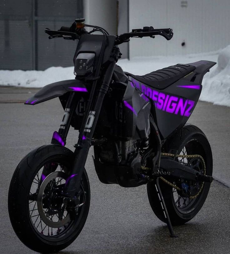 a black and purple dirt bike parked on the street