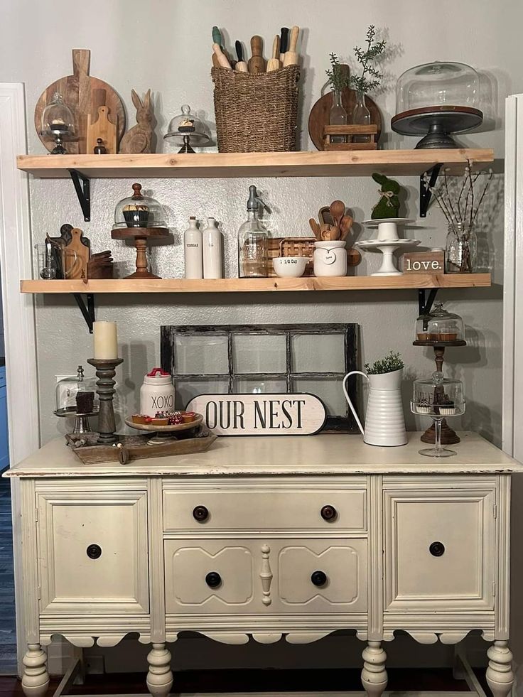 an old dresser with lots of clutter on the top and bottom shelves above it