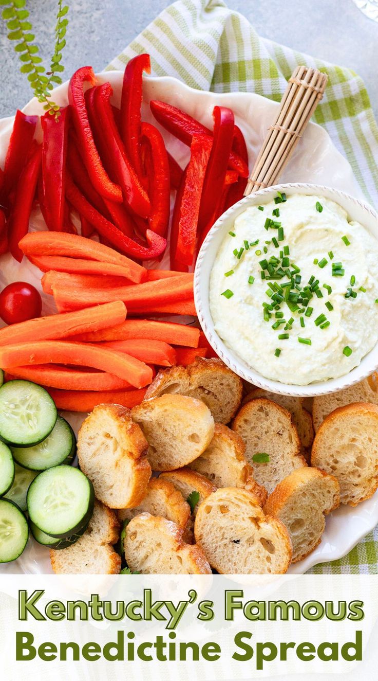 a white plate topped with bread and veggies next to a bowl of dip