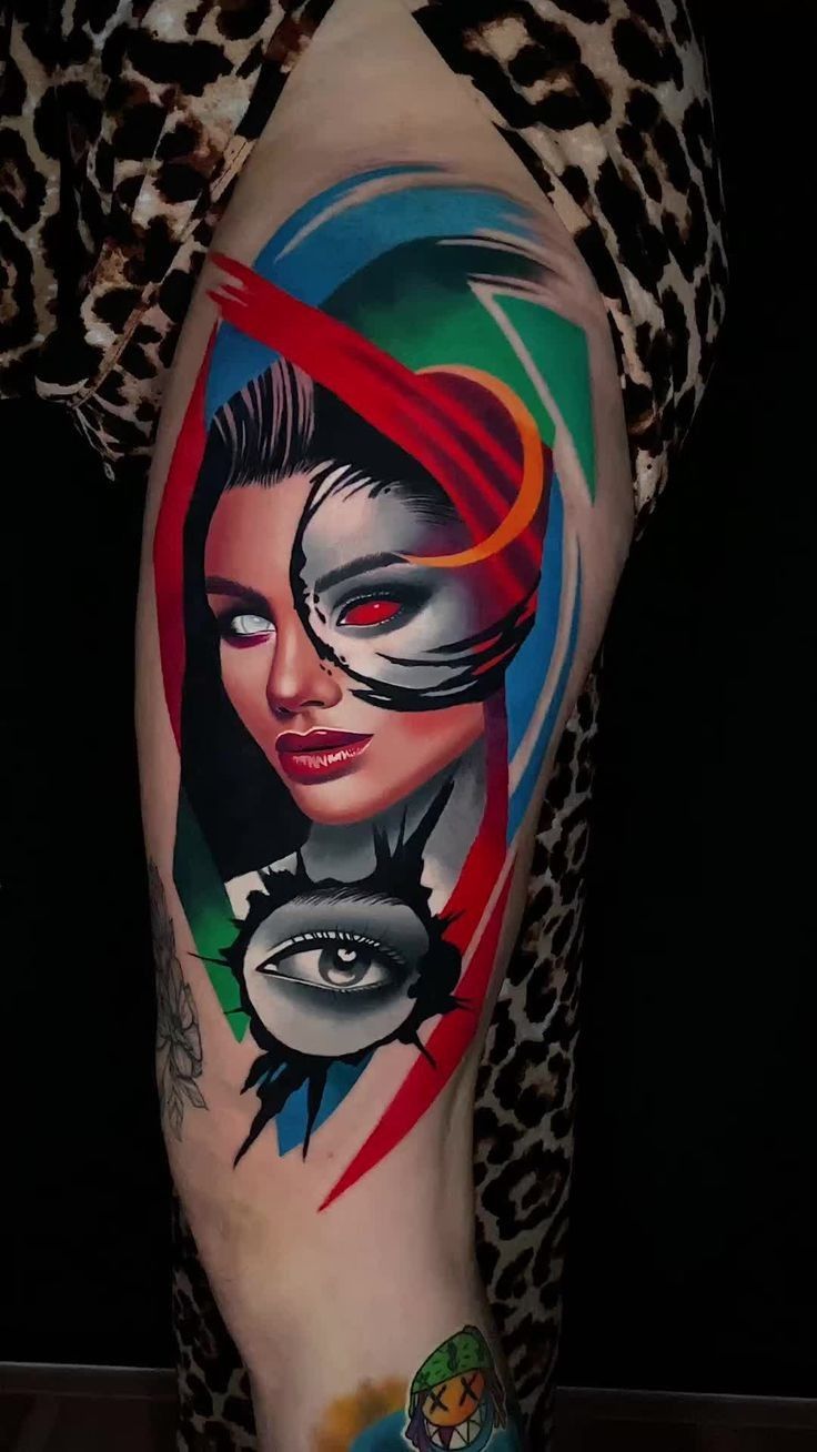 a woman's leg with tattoos on it and an eyeball in the middle