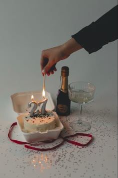 a person lighting a candle on a cake