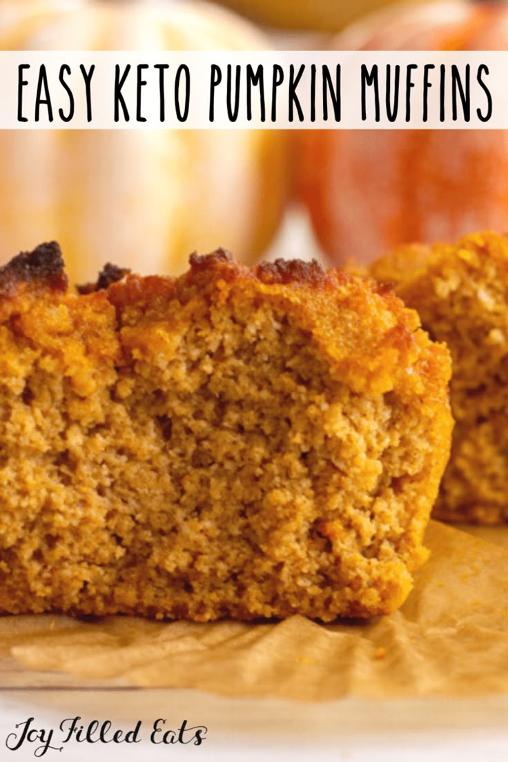 two pieces of pumpkin muffins sitting on top of a wooden cutting board next to an apple