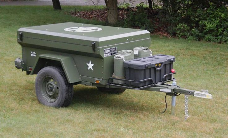 an army style utility trailer with two tanks attached to the back and side wheels on grass