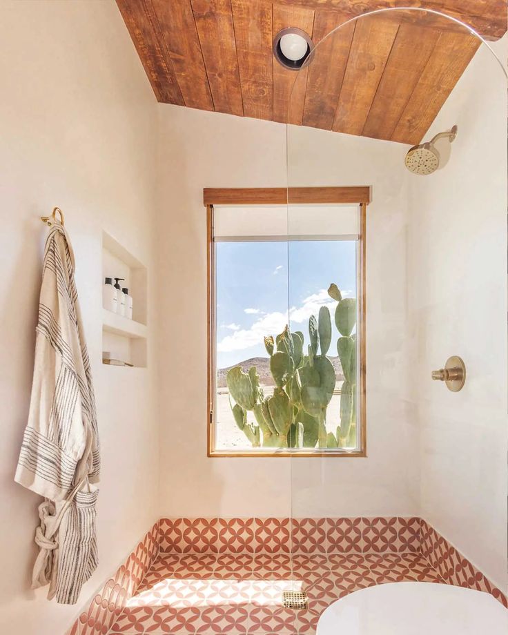 a white toilet sitting next to a window in a bathroom