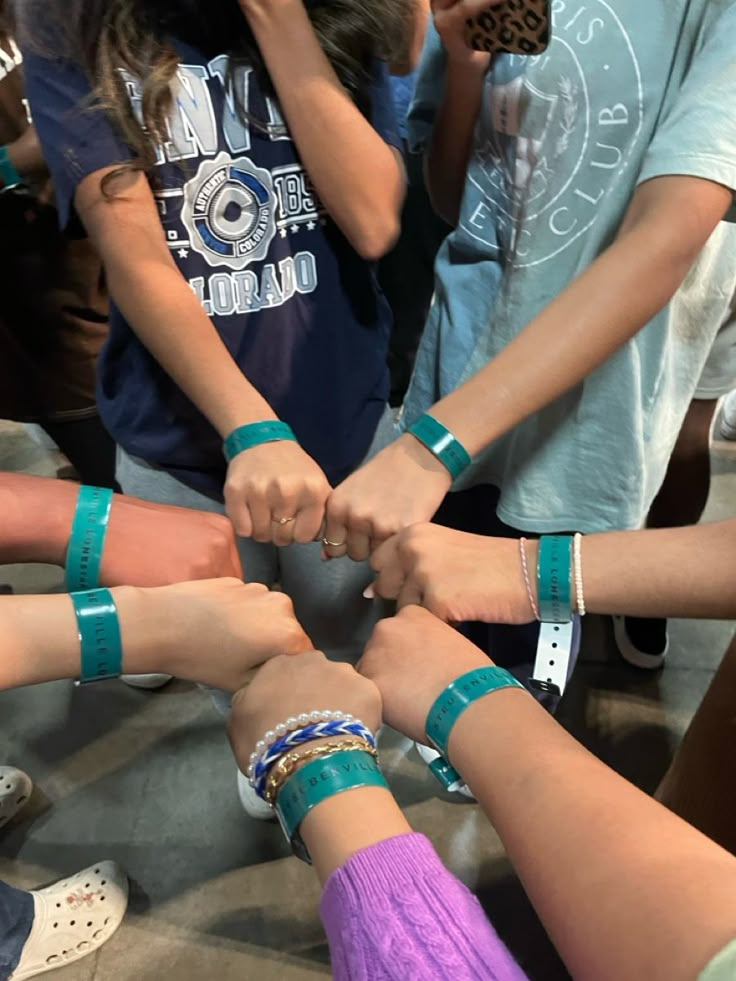 a group of people standing in a circle with their hands on top of each other