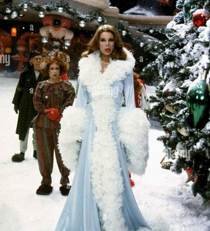 an image of a woman in costume walking through the snow with other people behind her