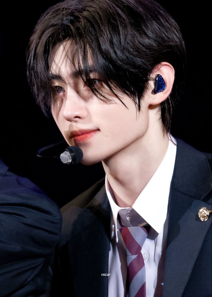 a young man wearing ear buds and a suit