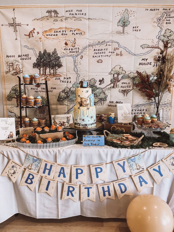 a happy birthday banner is hanging on the wall next to a table with cakes and cupcakes