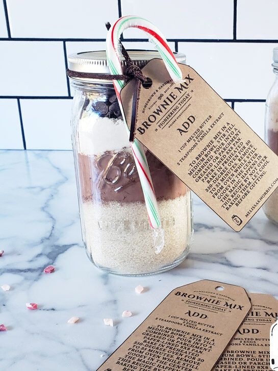 two mason jars filled with brownies and candy canes on top of a marble counter