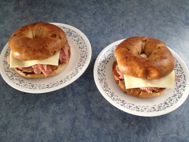 two white plates topped with donuts covered in meat and cheese on top of them