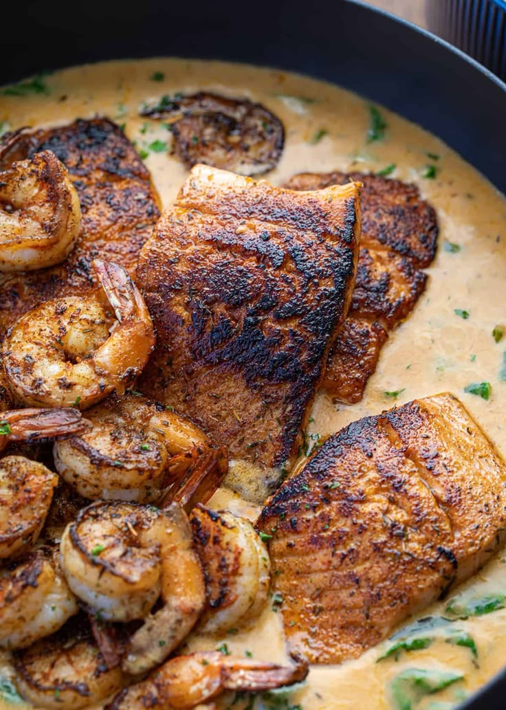 a pan filled with shrimp and grits on top of a table