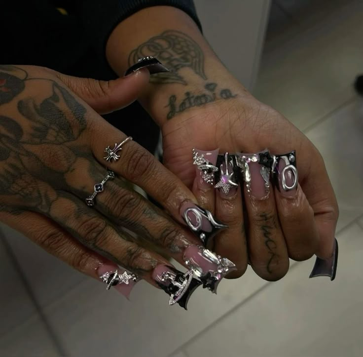 a person with tattoos on their arms and hands holding several rings in one hand while another holds the other