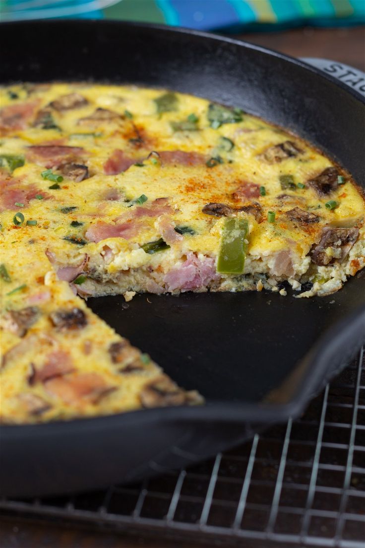 an omelet with meat and vegetables in a skillet on a cooling rack