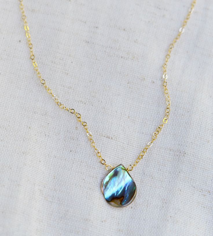 Looking for a unique necklace that captures the essence of the ocean and promotes feelings of peace and beauty? Look no further! Our handcrafted pendant features a teardrop-shaped genuine abalone shell in shades of green, blue, pink, cream, purple, and brown. Available in both sterling silver and 14k gold filled. It's the perfect gift for beach lovers!*The reverse side of the abalone is a tan color and can have natural imperfections along its surface. Pendant Size: average .75 x .5 inches (17x12mm)Modeled Size: 15 inches Handmade Teardrop Mother Of Pearl Jewelry, Mother Of Pearl Drop Jewelry For Gift, Drop-shaped Mother Of Pearl Jewelry For Gifts, Turquoise Necklace With Pearl Drop As Gift, Turquoise Necklace With Pearl Drop For Gift, Handmade Teardrop Abalone Shell Jewelry, Elegant Abalone Shell Necklace As Gift, Elegant Abalone Shell Necklace For Gift, Bohemian Teardrop Pendant Drop Necklace Gift