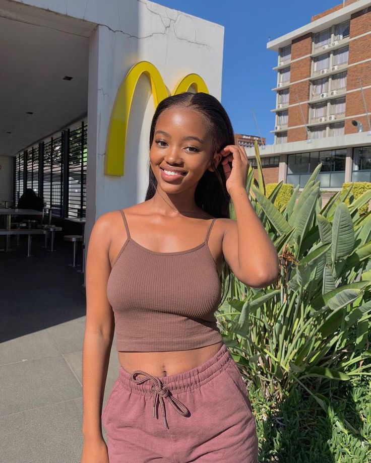 a woman standing in front of a mcdonald's sign with her hand on her head