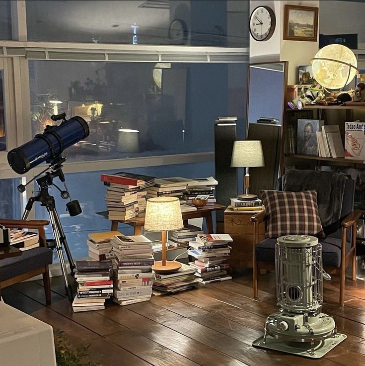 a living room filled with furniture and a telescope on top of a hard wood floor