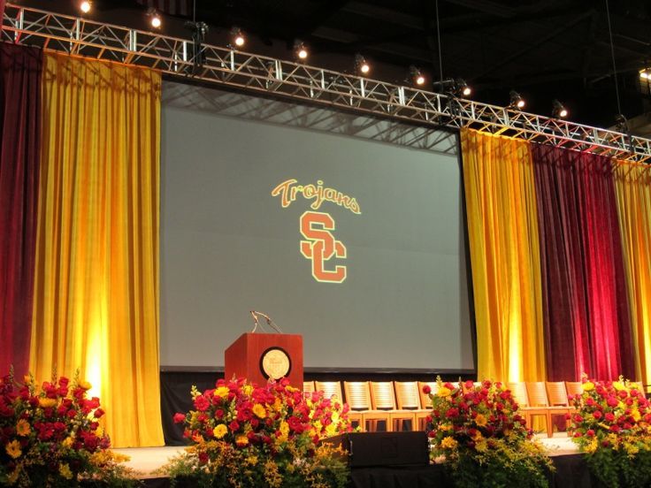 the stage is set up for an event with red and yellow drapes on it