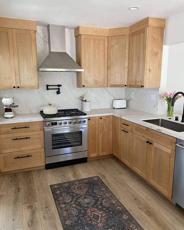 a kitchen with wooden cabinets and stainless steel stove top oven, sink, dishwasher and microwave