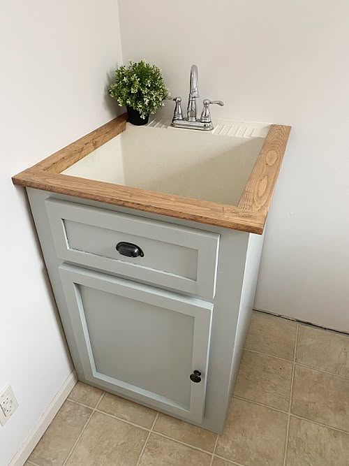 a kitchen sink with a wooden counter top