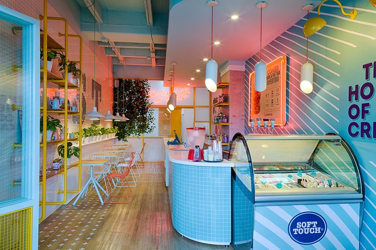 the interior of a restaurant with bright colored walls and flooring, including an ice cream display case