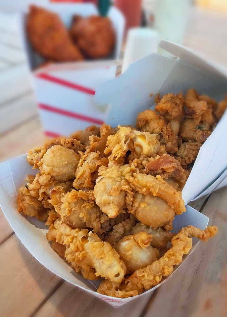 fried food sitting in a bowl on top of a wooden table