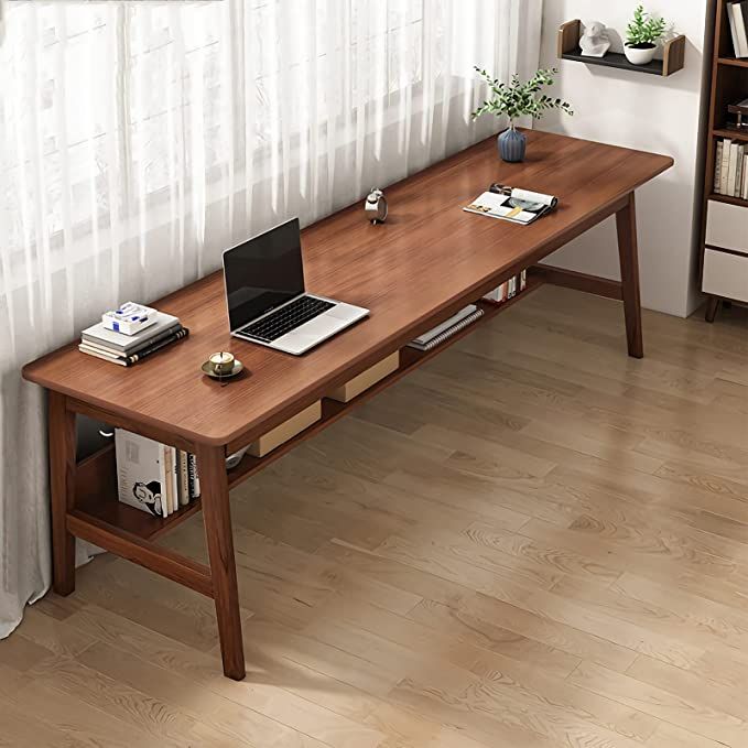 a wooden table with a laptop on it in front of a white curtained window