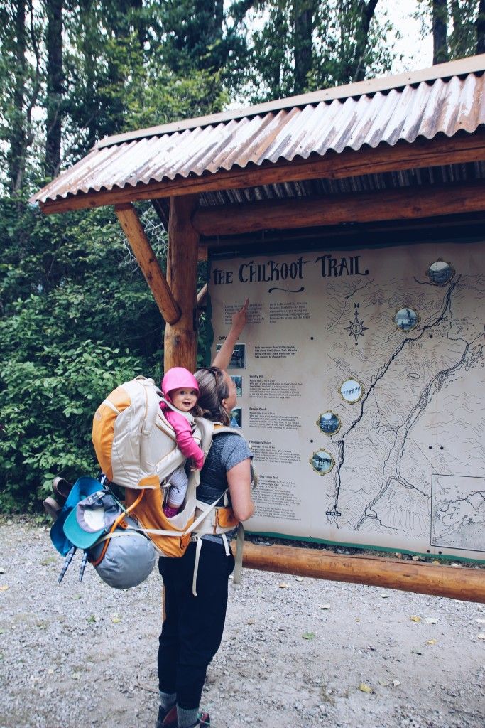 a woman and her child are standing in front of a sign that says the chimbo trail