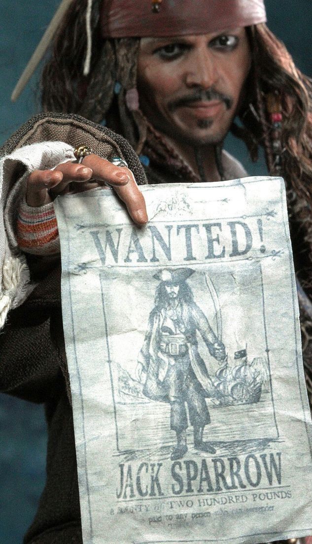 a close up of a person holding a paper with a pirate on it's face