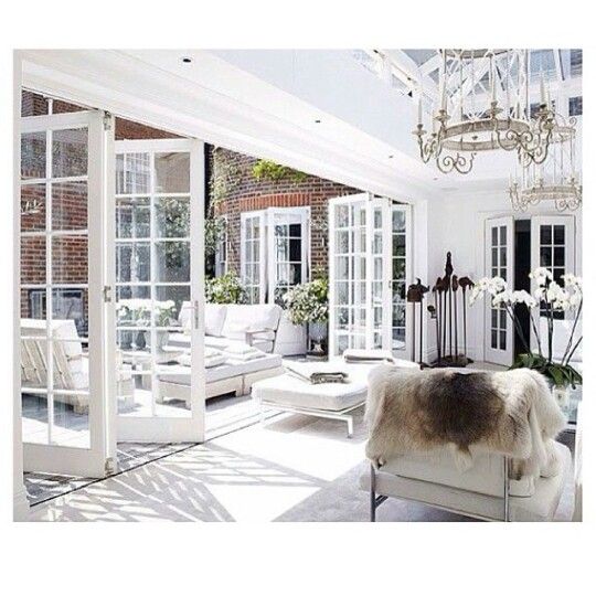 the sun shines through the windows in this white living room with couches and chairs